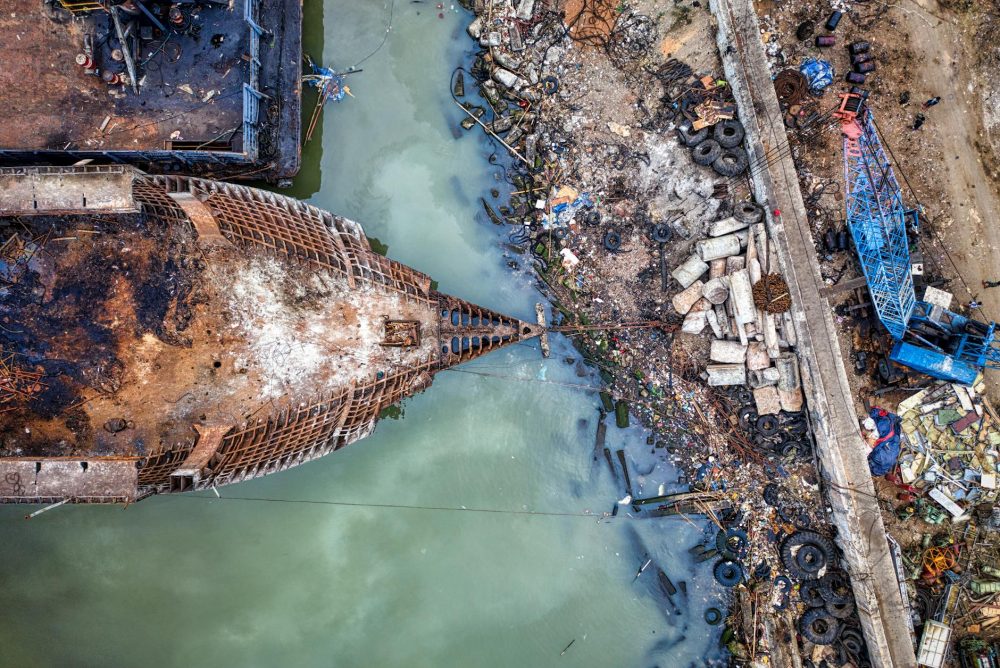 old destroyed ship moored on dirty seashore